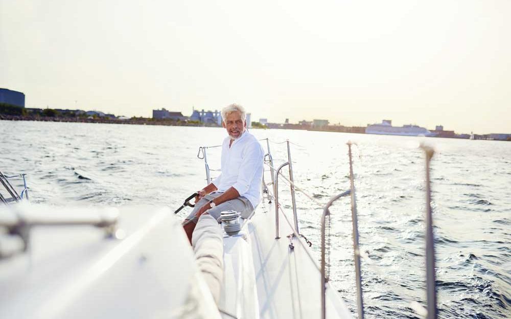 mature-man-out-sailing-his-yacht-on-a-sunny-GXB95PE