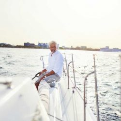 mature-man-out-sailing-his-yacht-on-a-sunny-GXB95PE